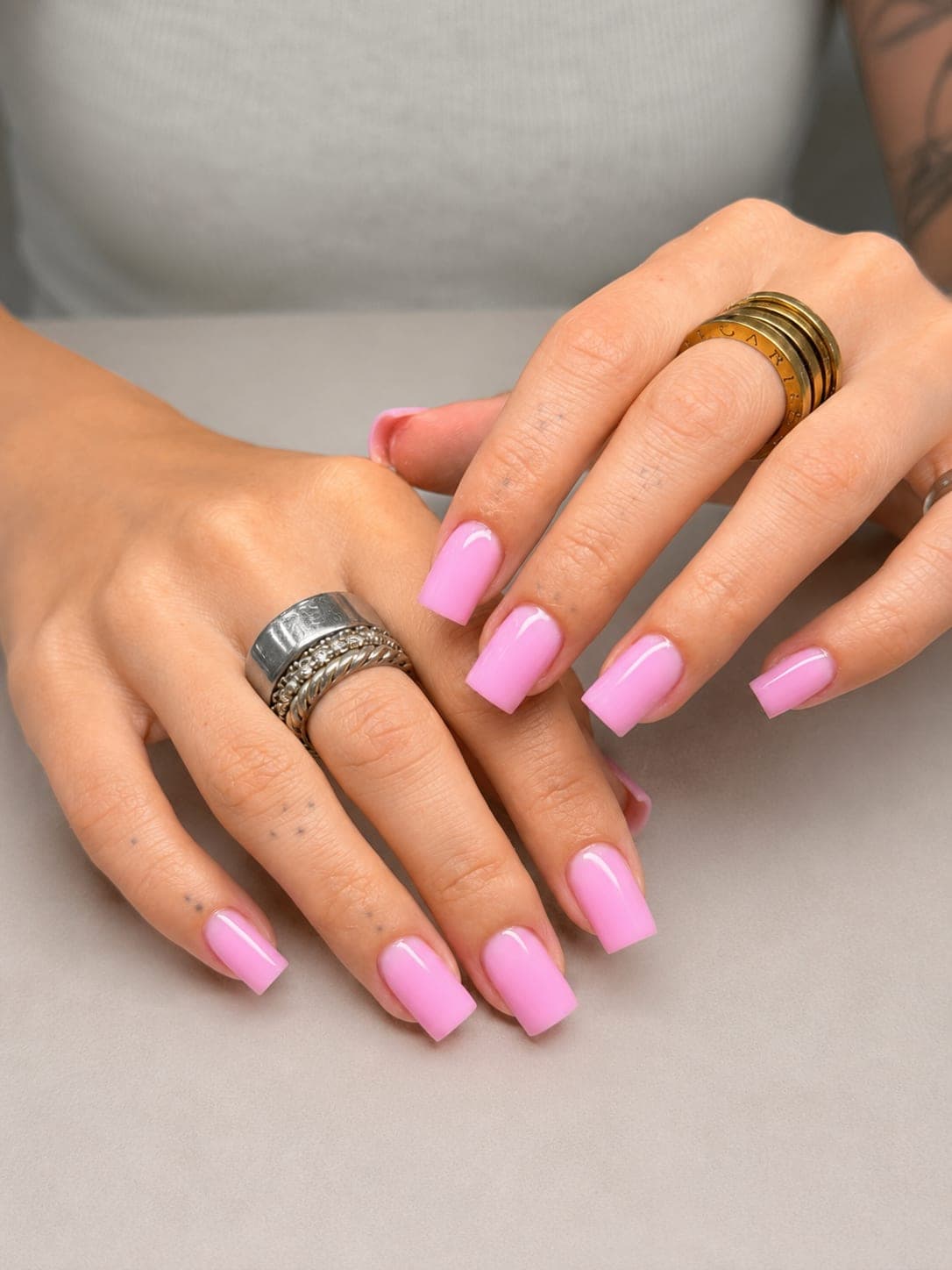 Bubblegum pink long square nails with stacked rings