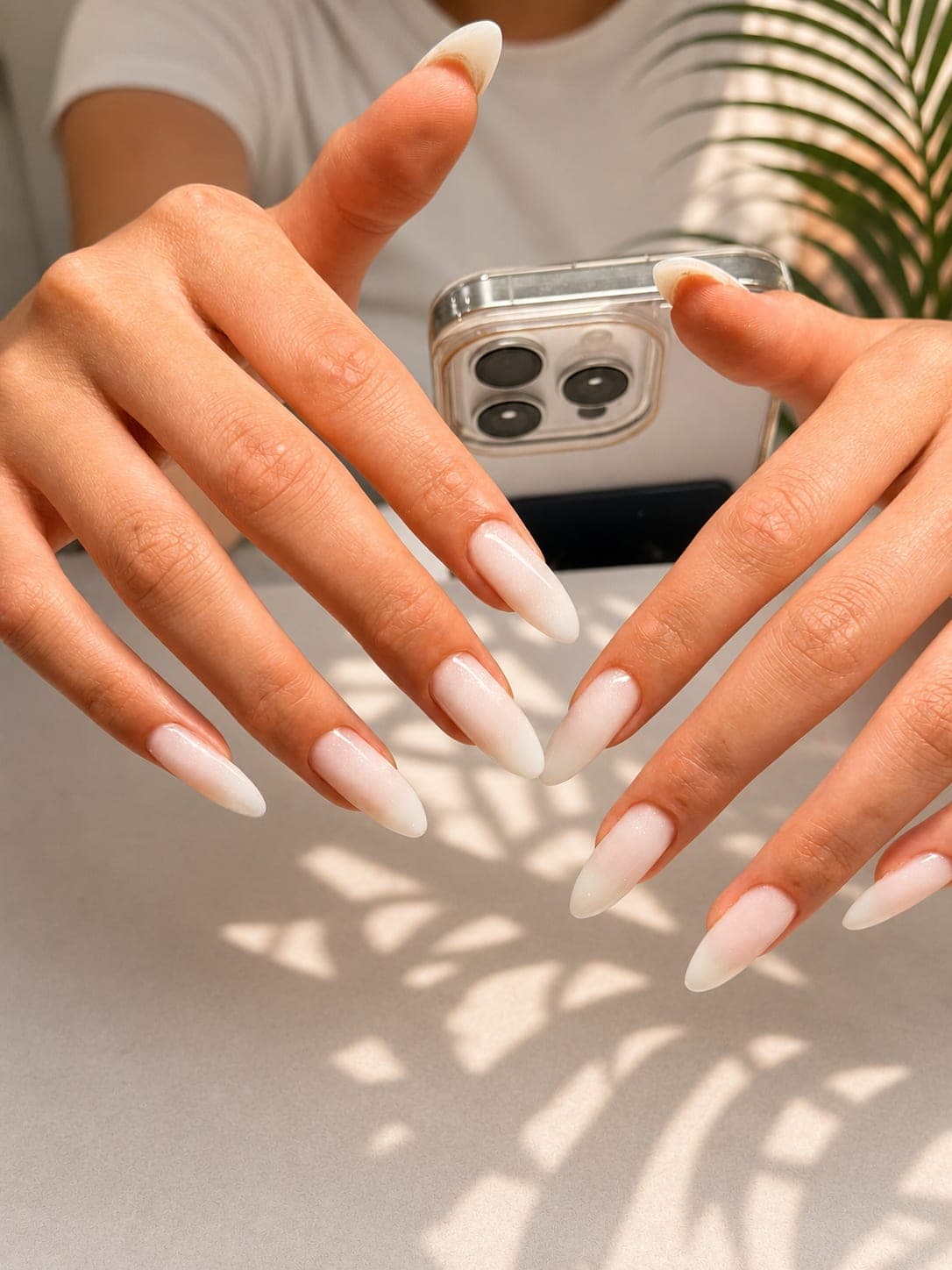 Milky white almond nails in warm daylight