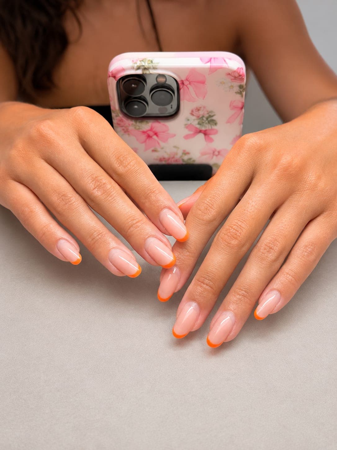 Orange French tips on oval nails