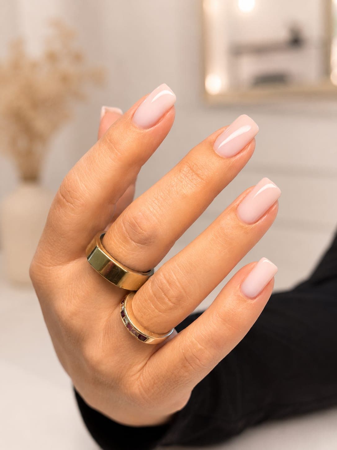 Russian manicure with nude gel polish, hand with gold rings